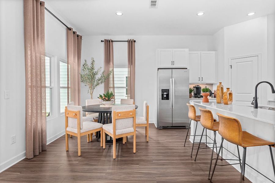 A kitchen with a table and chairs.