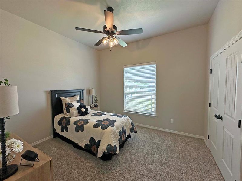 Bedroom with light carpet, ceiling fan, and a closet Bedroom with light carpet, ceiling fan, and a closet
