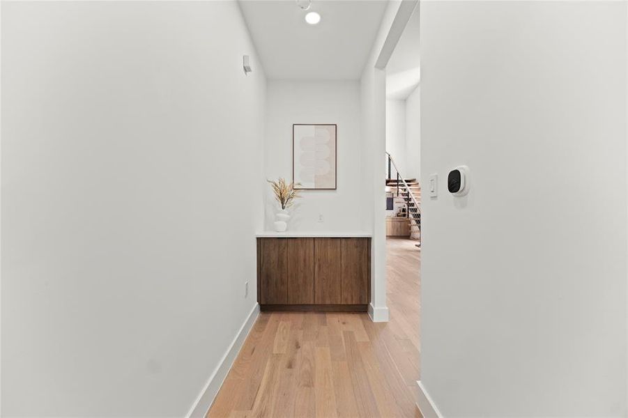 Corridor with light hardwood / wood-style flooring