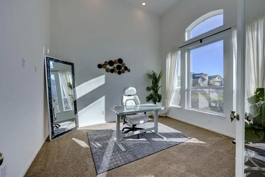 Office space with a high ceiling and light colored carpet