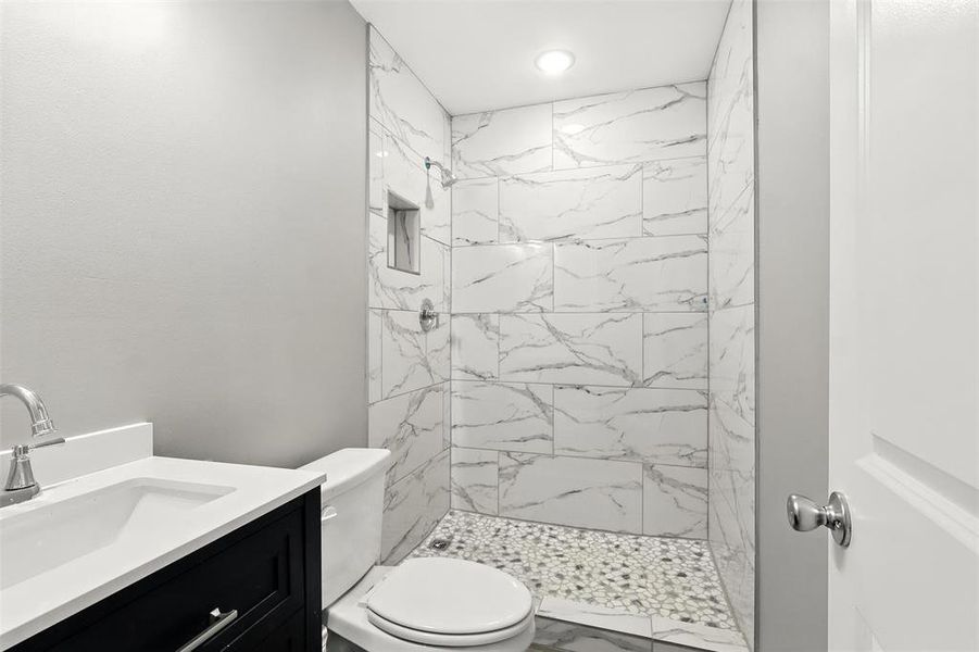 Bathroom featuring a marble finish shower, vanity, recessed lighting, and marble finish flooring Bathroom featuring a marble finish shower, vanity, recessed lighting, and marble finish flooring