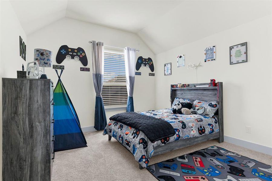 Bedroom featuring lofted ceiling and carpet floors Bedroom featuring lofted ceiling and carpet floors