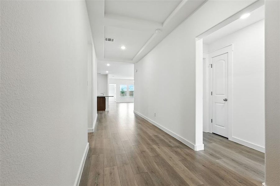 Hall with light wood-type flooring and recessed lighting