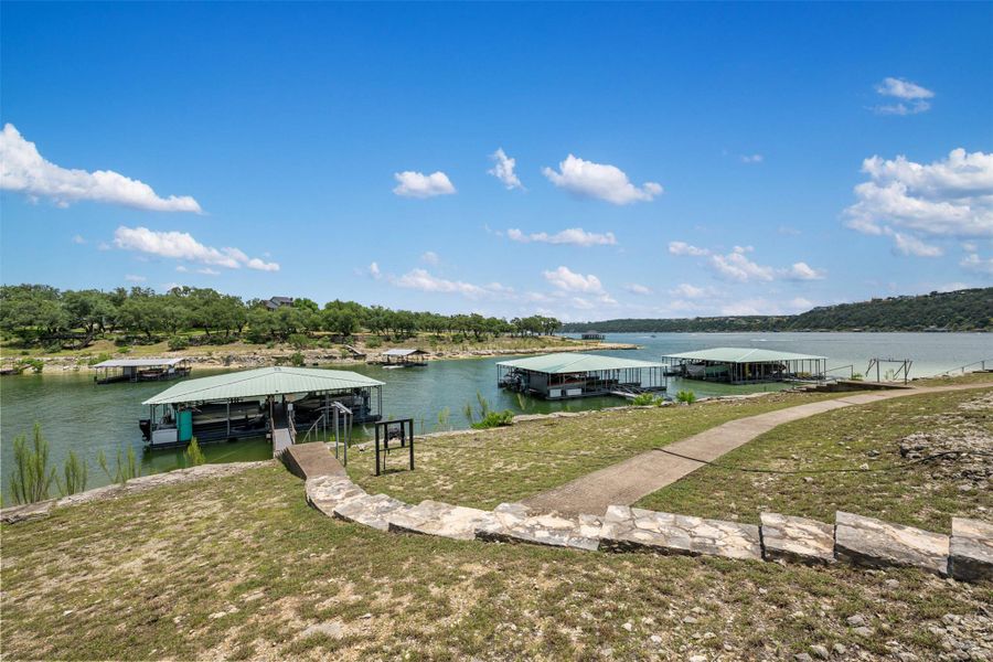 A tranquil lake view unfolds with several boat docks against a lush, verdant shoreline. A tranquil lake view unfolds with several boat docks against a lush, verdant shoreline.
