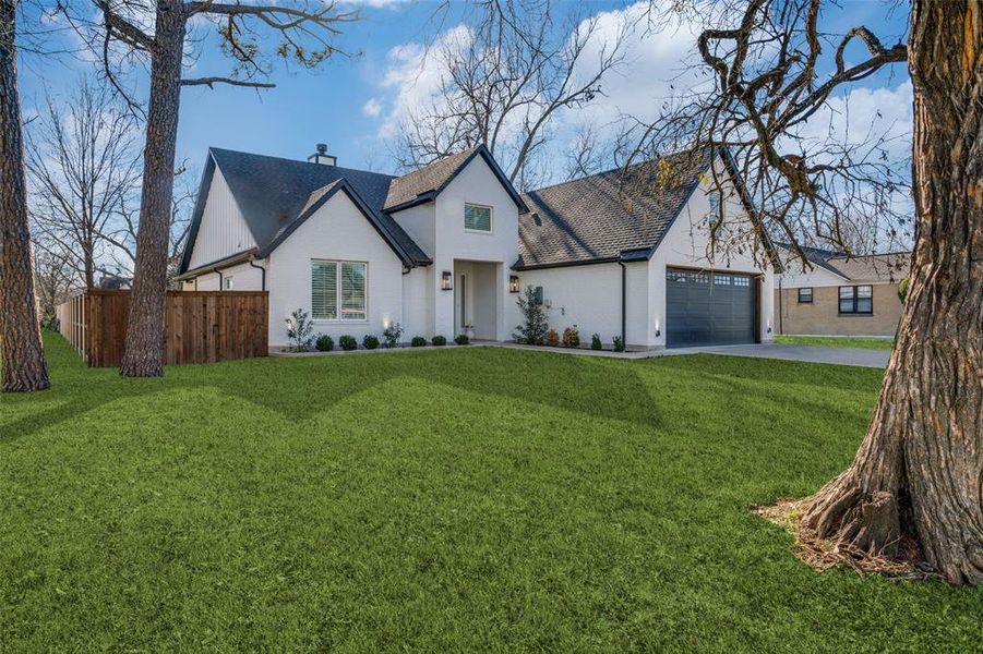 View of front of property featuring a garage and a front lawn