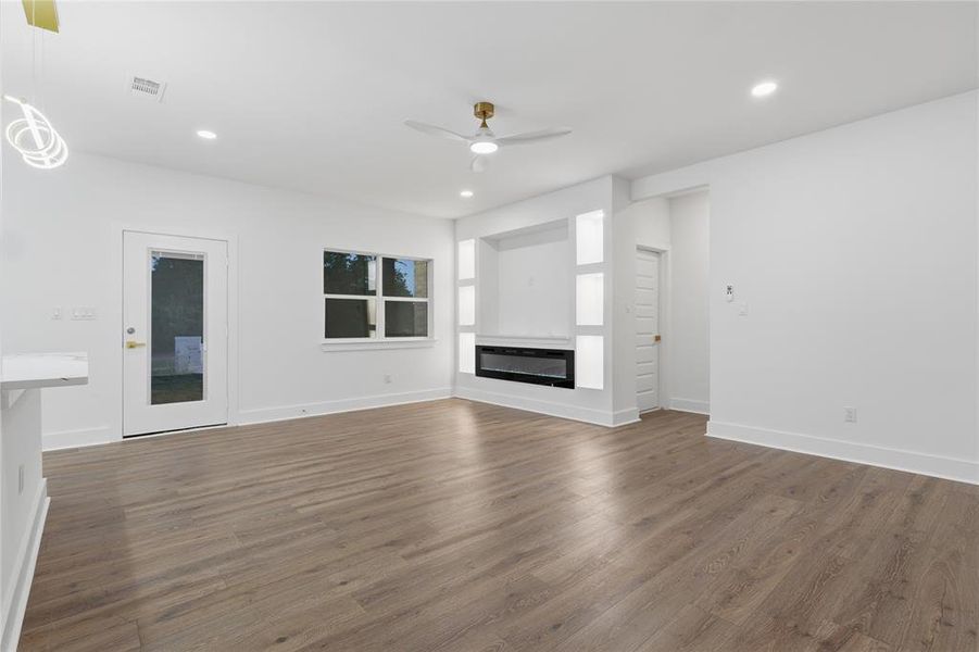 Spacious interior featuring wood-finish flooring, recessed lighting, and a contemporary ceiling fan
