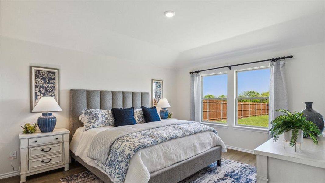 Bedroom with dark wood-style floors and vaulted ceiling