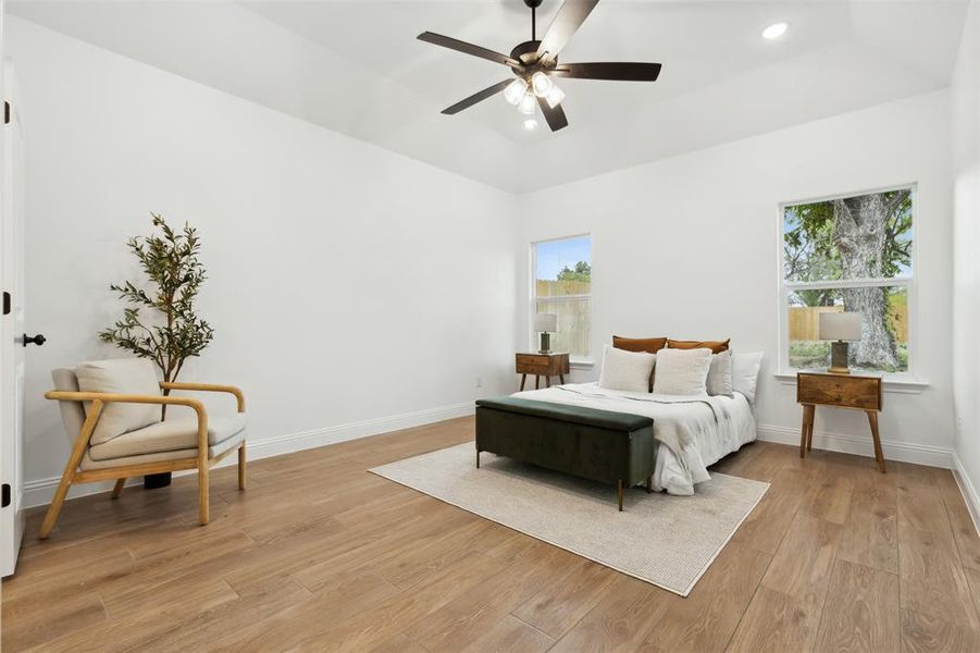 Bedroom featuring light wood-type flooring, multiple windows, and ceiling fan