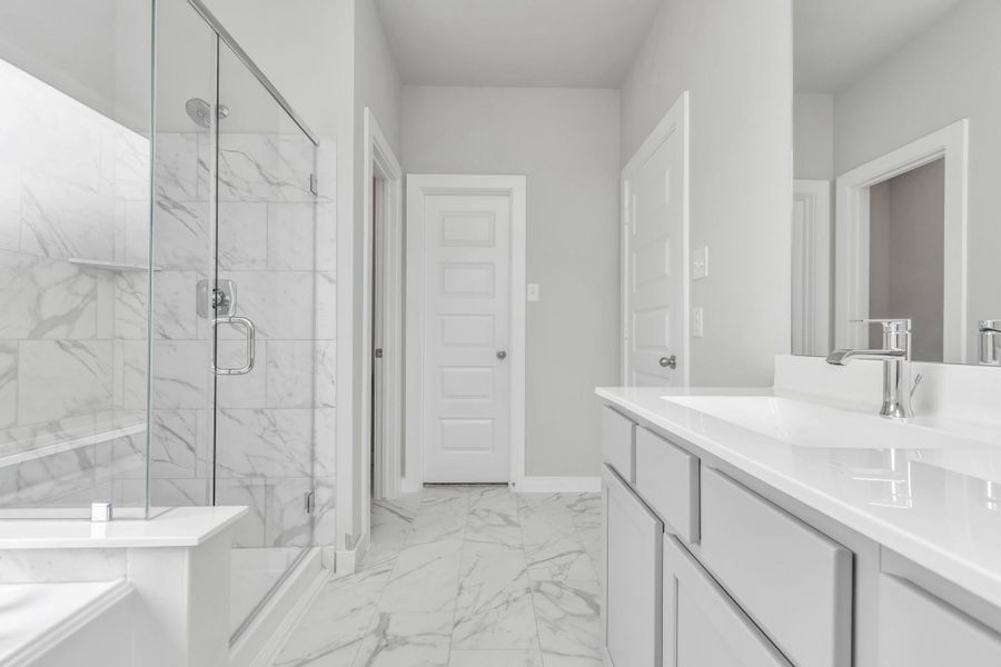 This additional view of the primary bath features a walk-in shower with the tile surround and separate garden tub perfect for soaking after a long day. Sample photo of completed home with similar floor plan. Actual colors and selections may vary.