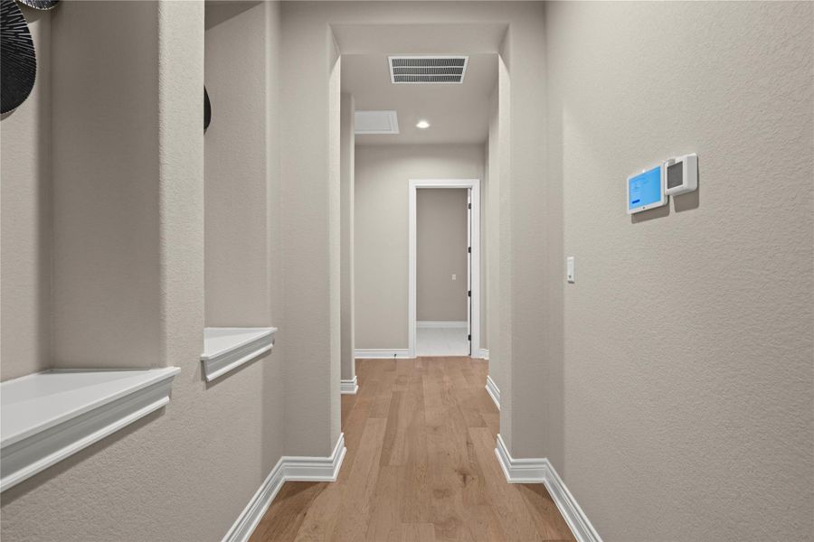 A streamlined hallway presents gleaming hardwood floors and neatly integrated wall niches, guiding the eye toward an inviting doorway. A streamlined hallway presents gleaming hardwood floors and neatly integrated wall niches, guiding the eye toward an inviting doorway.