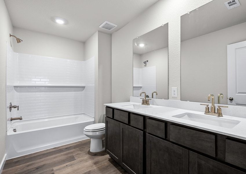 The secondary bathroom has a sprawling vanity space and a shower-tub combo.