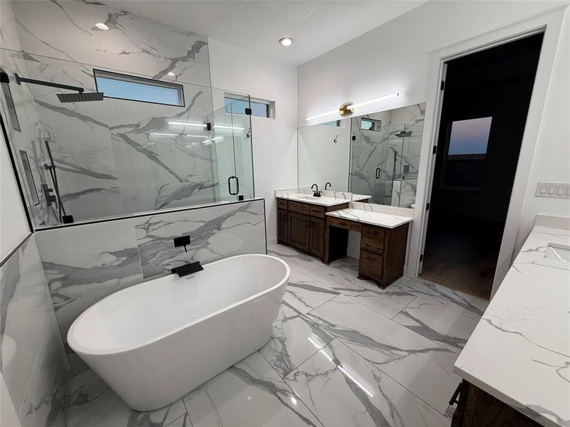 Full bath with two vanities, a freestanding tub, a marble finish shower, and light marble finish flooring Full bath with two vanities, a freestanding tub, a marble finish shower, and light marble finish flooring