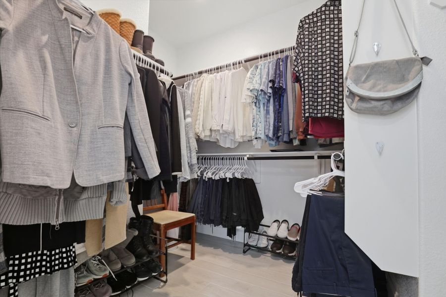 This spacious walk-in closet includes versatile built-in shelving and ample hanging space for organization.