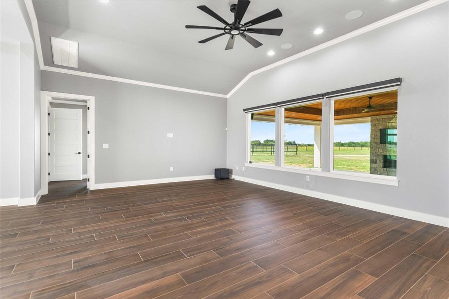 Spare room featuring crown molding, lofted ceiling, recessed lighting, wood finish floors, and ceiling fan Spare room featuring crown molding, lofted ceiling, recessed lighting, wood finish floors, and ceiling fan