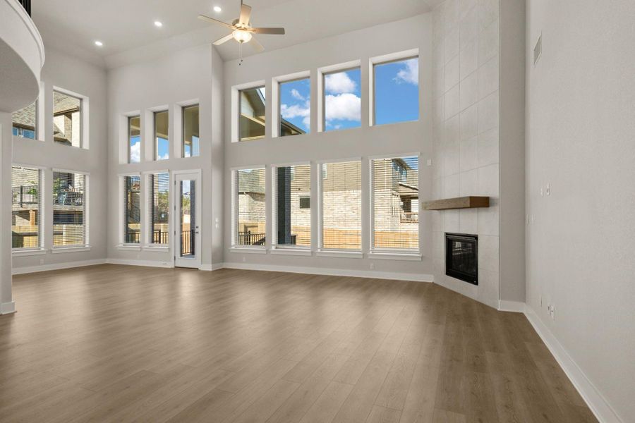 Soaring ceiling, floor to ceiling fireplace, and abundant windows in Open Concept Family Room