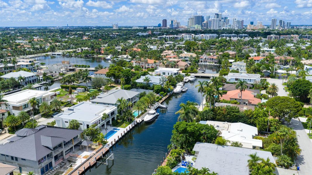 A sweeping aerial view of Fort Lauderdale’s luxury waterfront neighborhoods framed by canals, lush greenery, and the city skyline in the distance. A sweeping aerial view of Fort Lauderdale’s luxury waterfront neighborhoods framed by canals, lush greenery, and the city skyline in the distance.