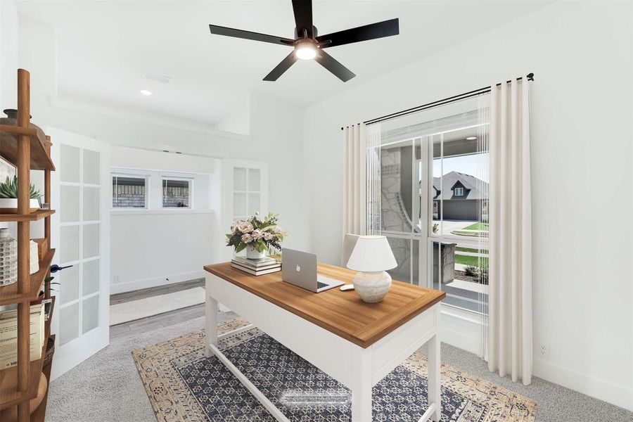 Home office with wood-top desk, ceiling fan, French doors, and large windows with natural light Home office with wood-top desk, ceiling fan, French doors, and large windows with natural light