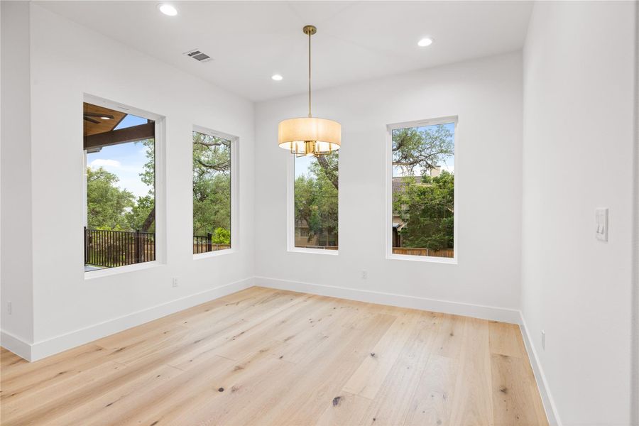 Dining area featuring engineered white oak flooring and plenty of natural light flowing in from large windows that offer view of the nicely tree shaded back yard. Dining area featuring engineered white oak flooring and plenty of natural light flowing in from large windows that offer view of the nicely tree shaded back yard.