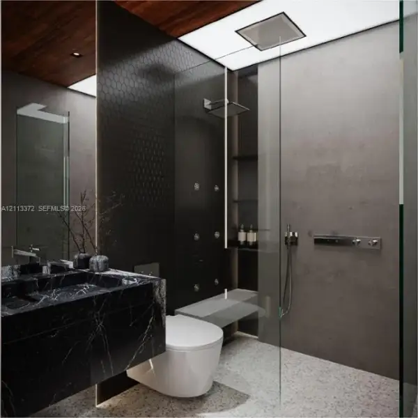 Custom floating vanity with a dark stone finish, walk-in shower featuring a recessed rain showerhead and body sprays, floor-to-ceiling glass enclosure, matte-finish wall tiles, and wood-finish ceiling detailing
