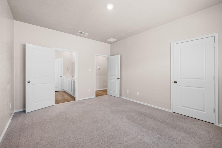 Unfurnished bedroom featuring light colored carpet and ensuite bath