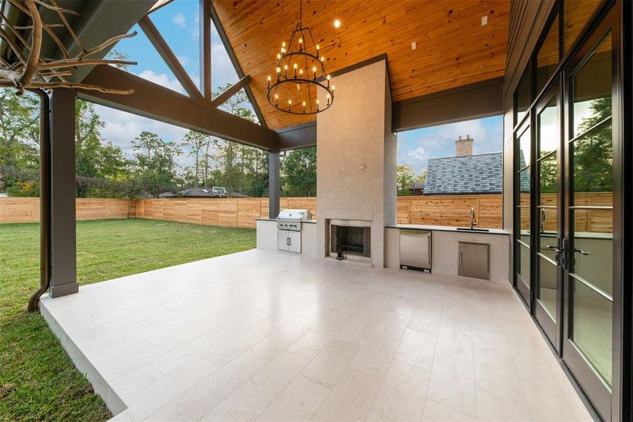 Out back the covered patio and kitchen make entertaining a breeze.