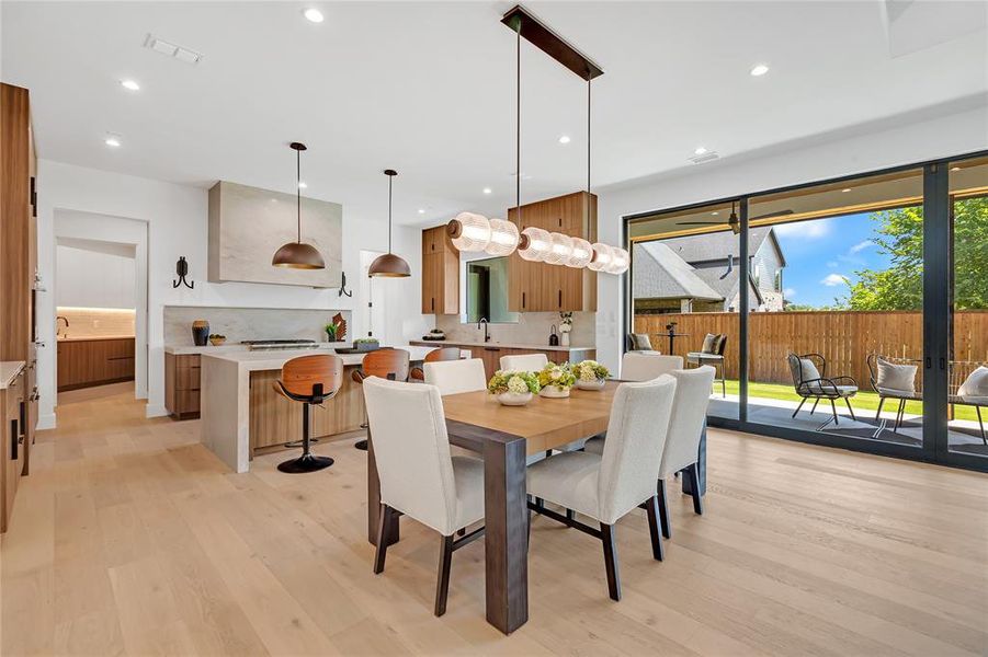 Dining room with light wood-style floors and recessed lighting Dining room with light wood-style floors and recessed lighting