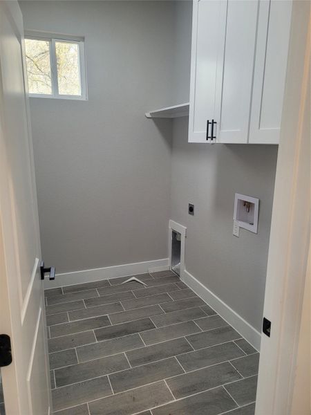 Laundry area featuring wood tiled floors, hookup for an electric dryer, cabinet space, and washer hookup