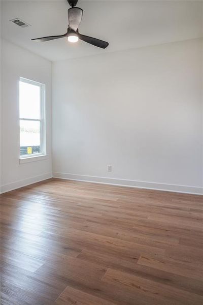 Empty room featuring hardwood / wood-style flooring and ceiling fan