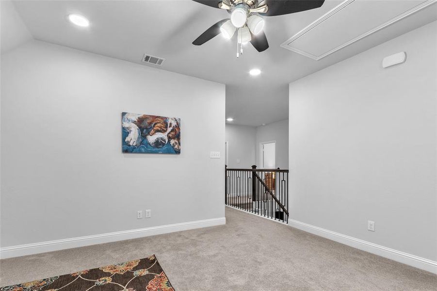 Unfurnished room with light carpet, attic access, visible vents, and baseboards