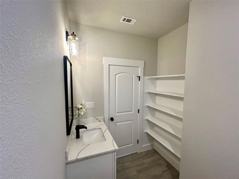 Secondary bathroom with shelving.