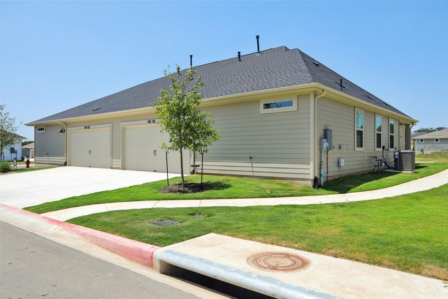 View of home's exterior featuring driveway, a shingled roof, a yard, and an attached garage View of home's exterior featuring driveway, a shingled roof, a yard, and an attached garage