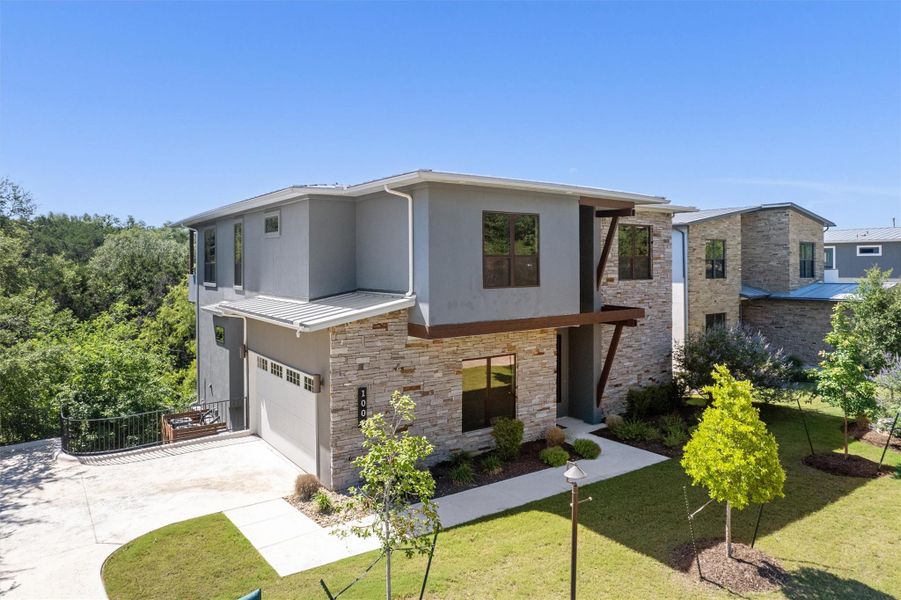 Modern architecture with clean lines and mixed materials, showcasing a well-maintained lawn and lush landscaping. Modern architecture with clean lines and mixed materials, showcasing a well-maintained lawn and lush landscaping.