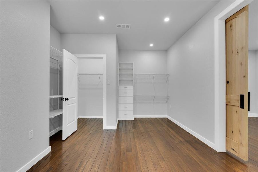 Walk in closet with wood-type flooring