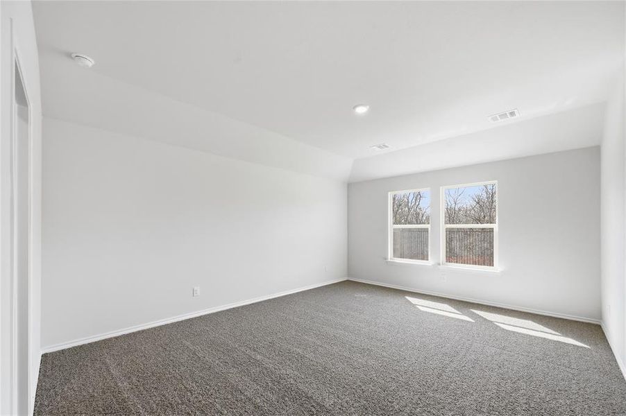 Spacious room featuring neutral carpeting, white walls, two large windows, recessed lighting, and a tray ceiling Spacious room featuring neutral carpeting, white walls, two large windows, recessed lighting, and a tray ceiling