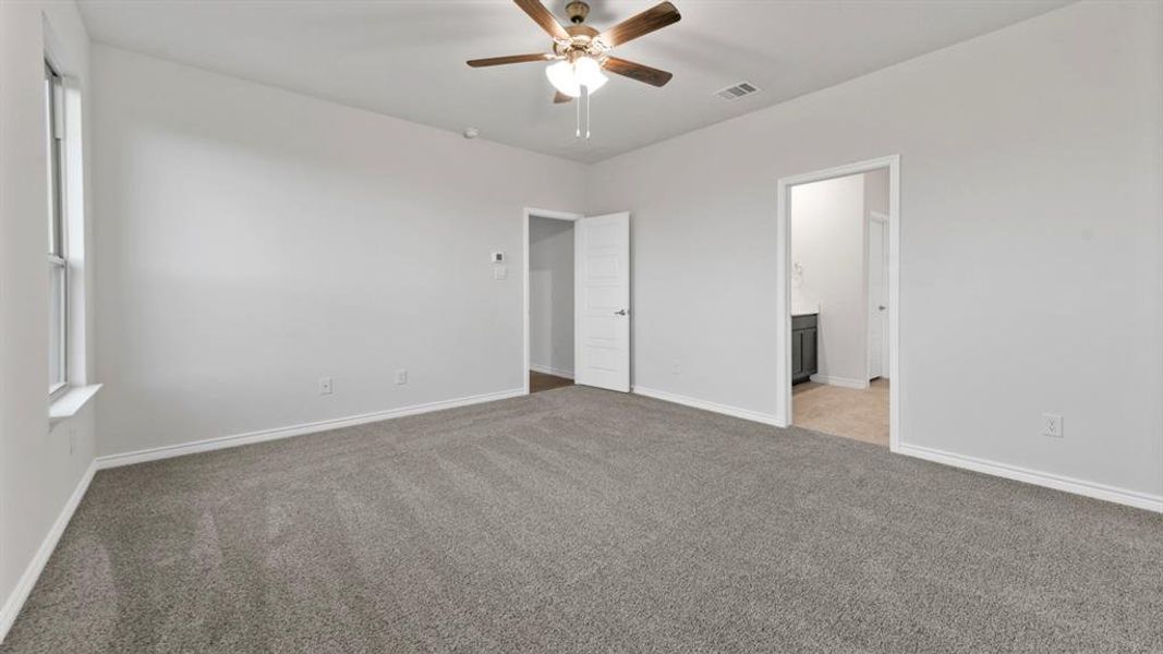 Unfurnished bedroom with light carpet, ceiling fan, and ensuite bathroom Unfurnished bedroom with light carpet, ceiling fan, and ensuite bathroom
