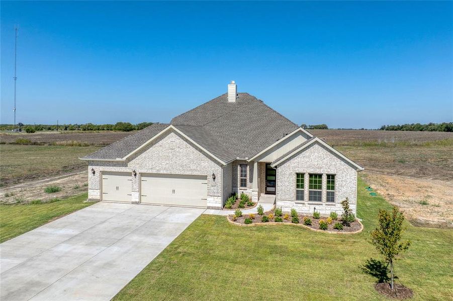 View of front of house featuring a garage and a front yard