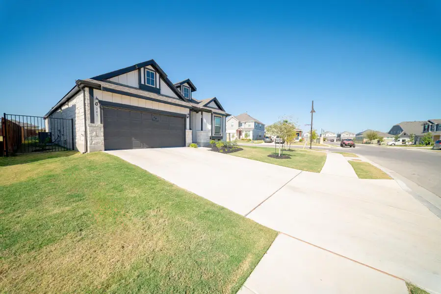 View of front of house with a residential view, concrete driveway, board and batten siding, a garage, and stone siding View of front of house with a residential view, concrete driveway, board and batten siding, a garage, and stone siding