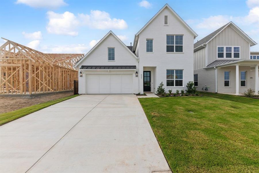 View of front of house featuring a garage and a front lawn