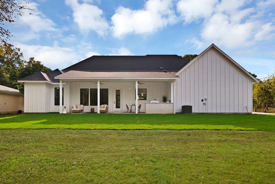 Back of property with board and batten siding, a patio area, and roof with shingles Back of property with board and batten siding, a patio area, and roof with shingles