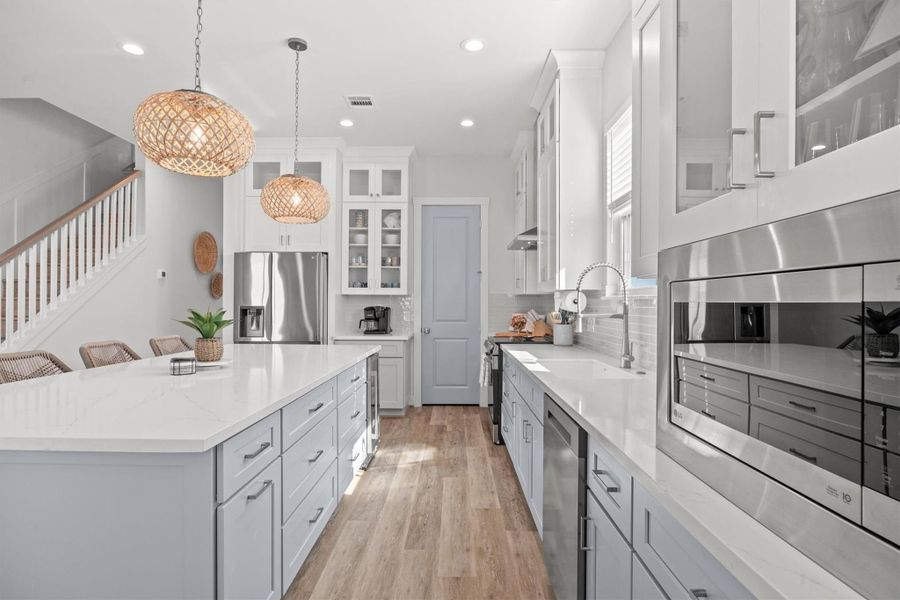 With built-in appliances, island drawers, and an abundance of storage, this kitchen is designed for both convenience and organization. Just beyond the stylish door, is an incredible walk-in pantry!