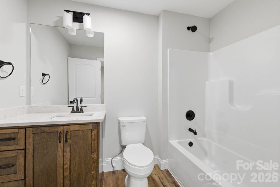 Above the garage, a third full bath is complemented by an expansive bonus room, creating a versatile and elevated living space.