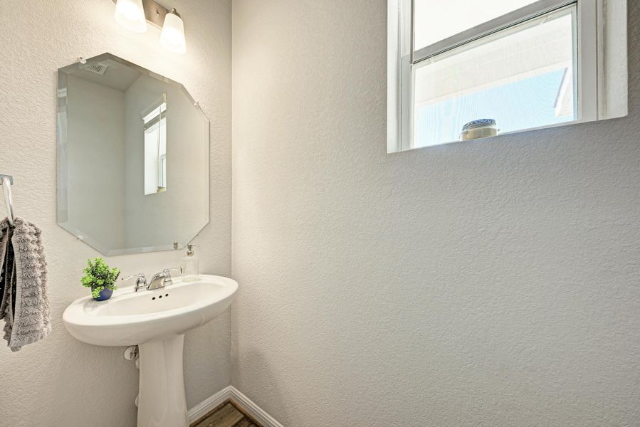 Bathroom featuring a textured wall and baseboards