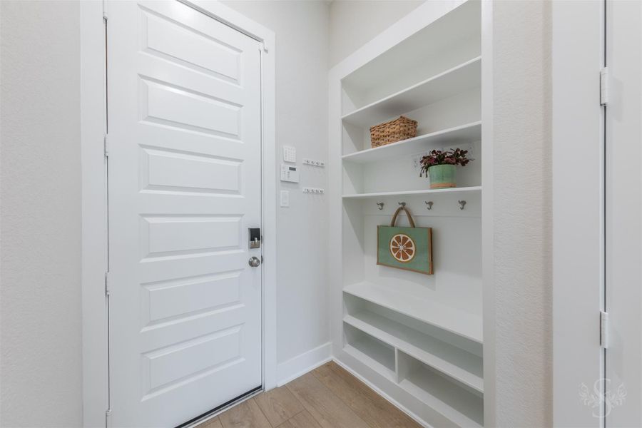 The Mud room provides a beautifully designed place to keep everyday essentials organized. Open shelving, hooks and lower storage add valuable convenience near the home’s secondary entrance. The Mud room provides a beautifully designed place to keep everyday essentials organized. Open shelving, hooks and lower storage add valuable convenience near the home’s secondary entrance.