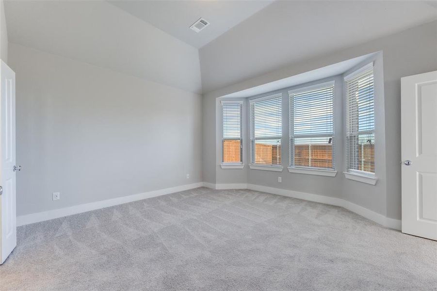 Spare room with light carpet and vaulted ceiling