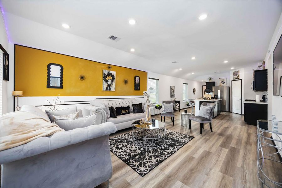 Open-concept living area that seamlessly connects to a sleek kitchen with stainless steel appliances and a spacious island, perfect for entertaining.