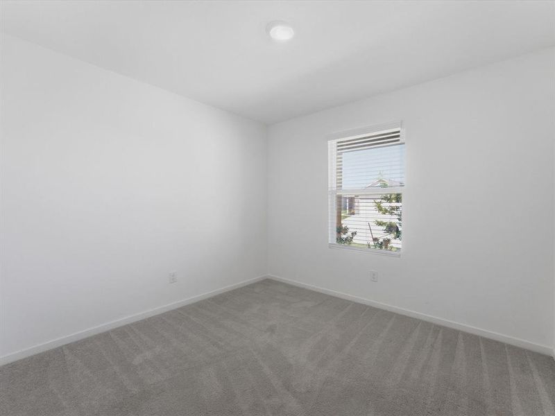 Bright room featuring soft gray patterned carpeting, a white ceiling, and a single window with horizontal blinds
