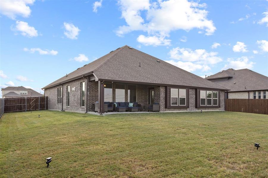 Rear view of house featuring a lawn, an outdoor hangout area, and a patio area