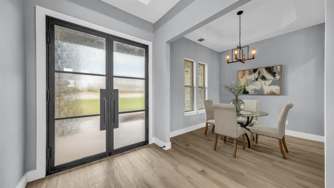 Dining space with light wood-style floors and a chandelier