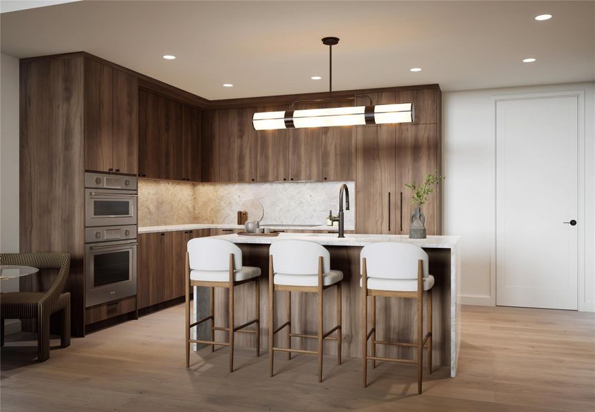 Kitchen in Trailhead palette featuring a large island with seating, designer lighting, wood flooring, recessed lights, and natural stone quartzite countertops. Includes a full Thermador appliance suite with refrigerator, wall oven, dishwasher, and induction cooktop. Soft, light-toned cabinetry and thoughtful detailing create an airy, refined space.