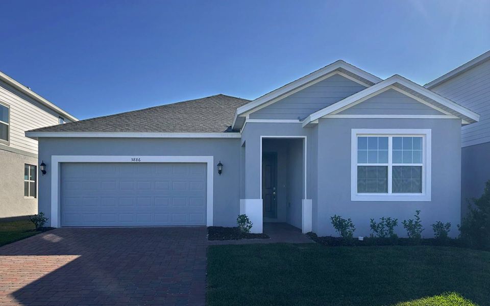 Front exterior of a new home in Trinity Place, St. Cloud, FL, highlighting curb appeal (Image 1). Front exterior of a new home in Trinity Place, St. Cloud, FL, highlighting curb appeal (Image 1).